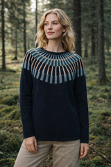 Woman wearing a black sweater with a patterned yoke in a forest setting